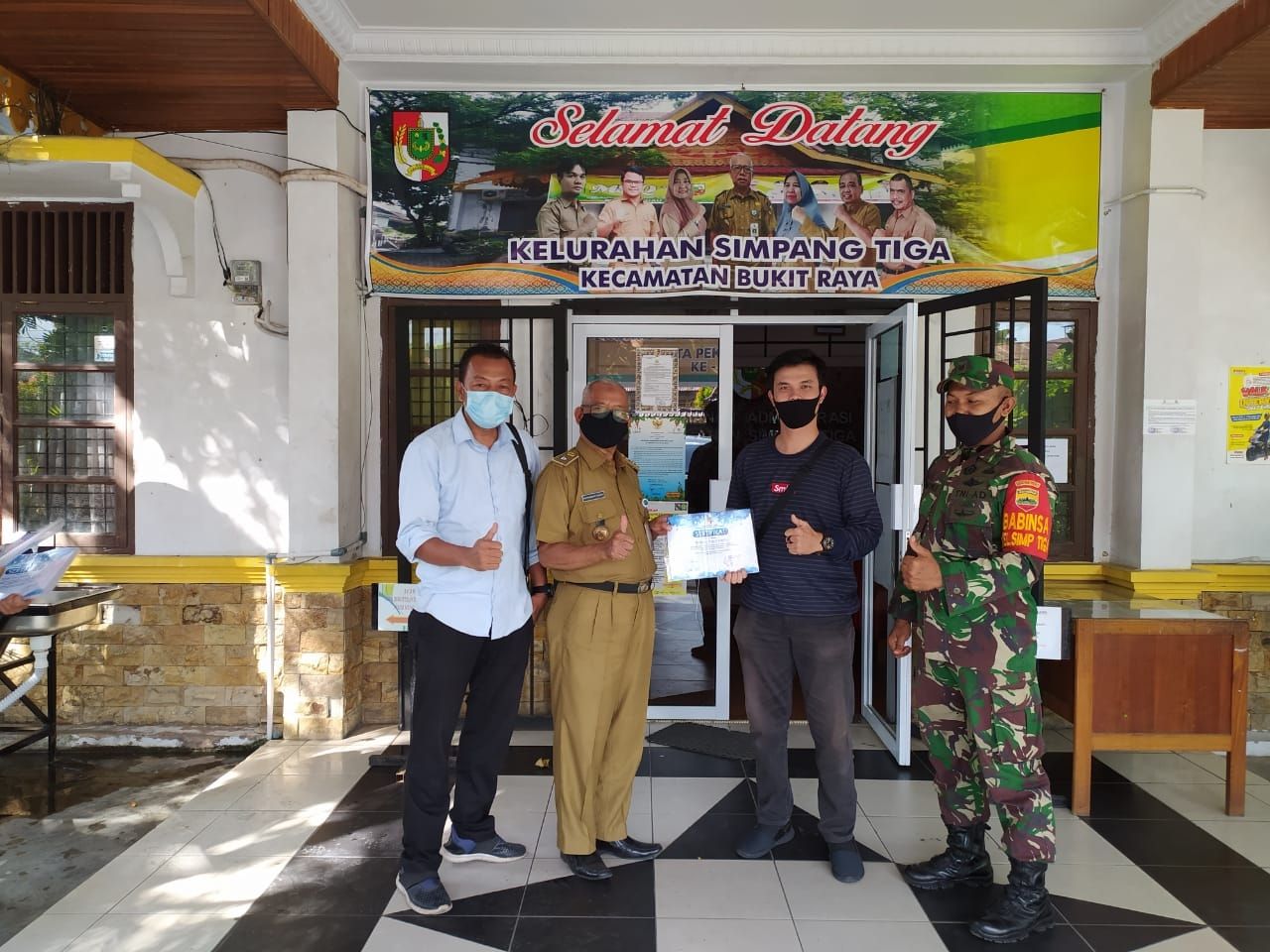 Babinsa Kodim 0301/PBR Dampingi Lurah Simpang Tiga Membagikan Sertifikat Kepada Relawan Mahasiswa UNRI