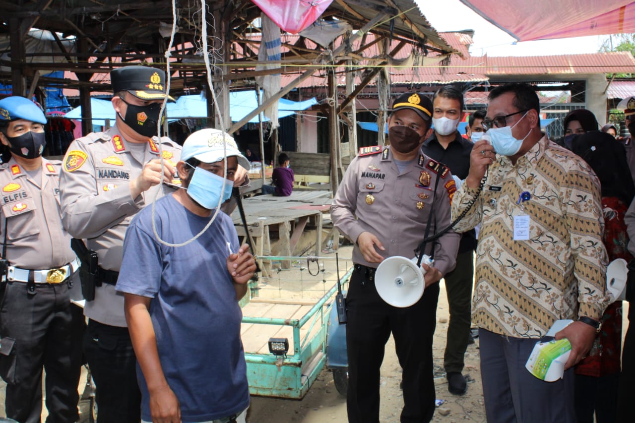 Polresta Pekanbaru Bagikan 1.000 Masker di Pasar Tangor dan Berikan Bantuan Sembako Untuk Warga