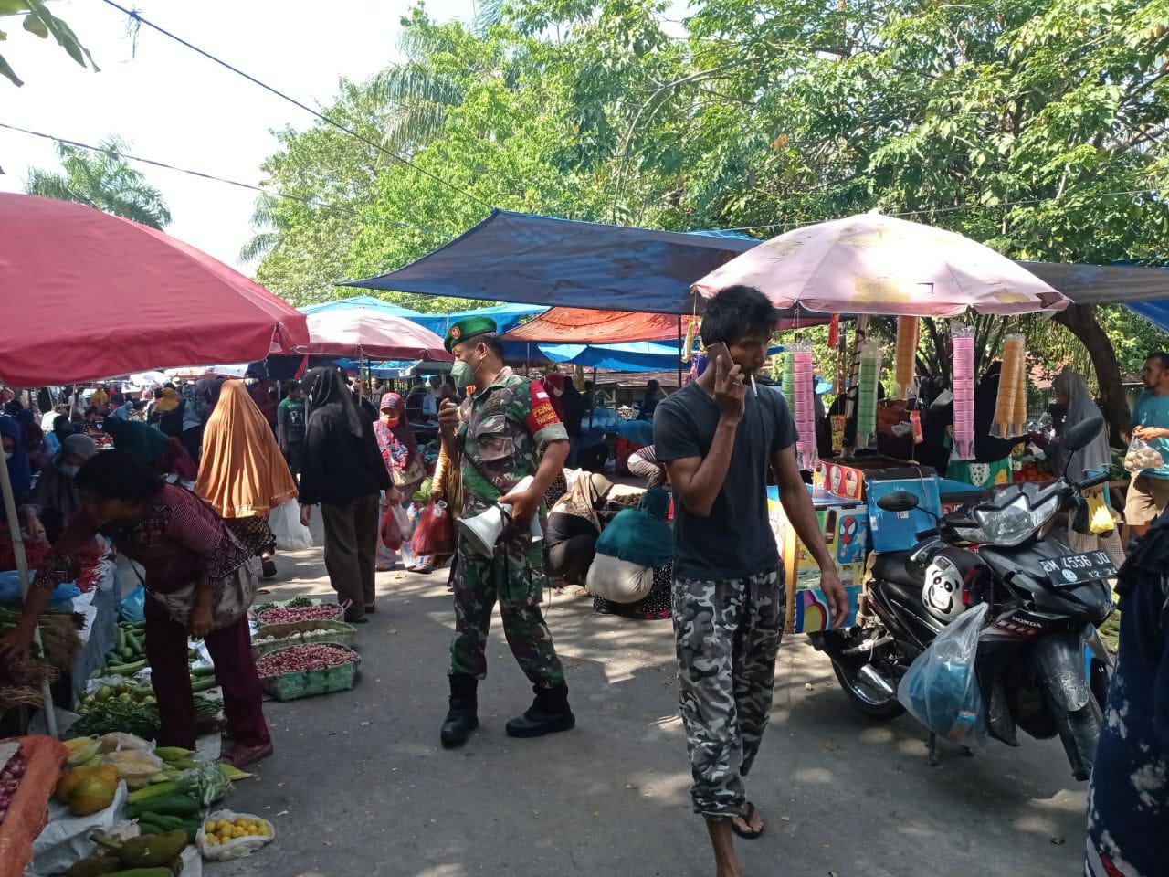 Gunakan Pengeras Suara, Babinsa Kodim 0301/PBR Berikan Himbauan Prokes Di Pasar Rumbai