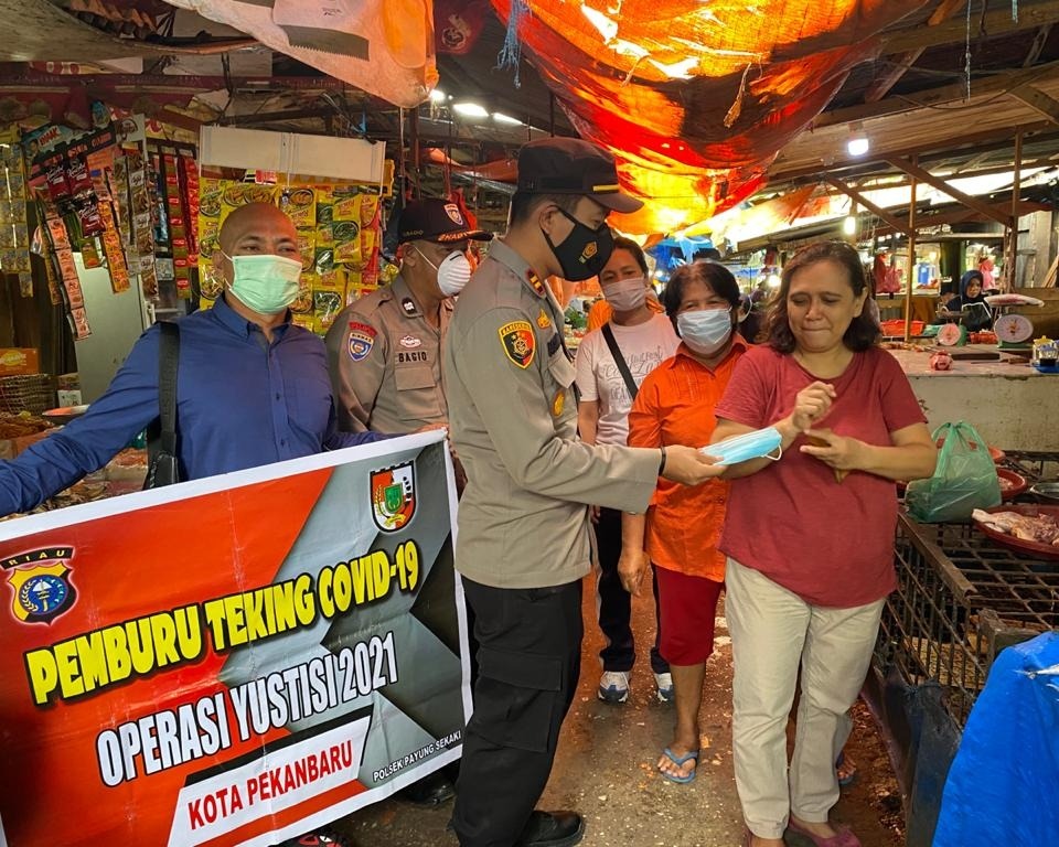 Cegah Penyebaran Covid-19, Kapolsek Payung Sekaki Bagikan Masker Gratis Kepada Pedagang dan Pengunjung Pasar Pagi Palapa