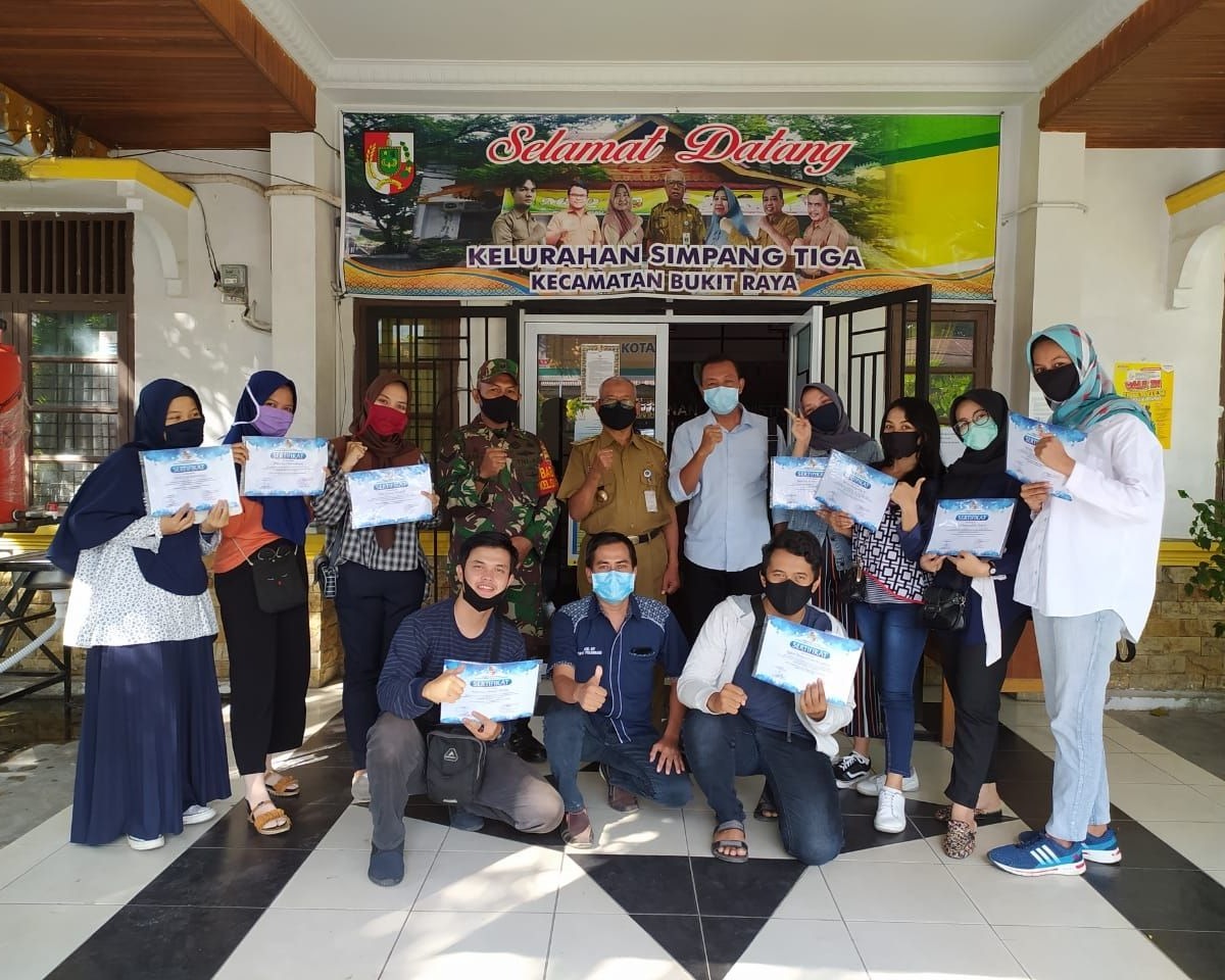 Babinsa Kodim 0301/PBR Dampingi Lurah Simpang Tiga Membagikan Sertifikat Kepada Relawan Mahasiswa UNRI